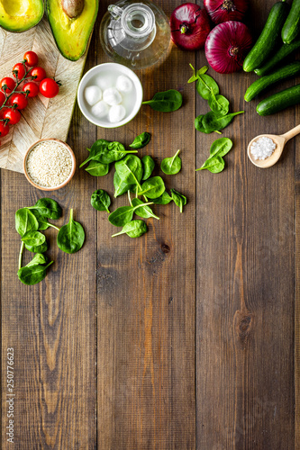 Fototapeta Naklejka Na Ścianę i Meble -  Fresh organic vegetables on dark wooden background top view copy space. Kitchen desk for preparing salad