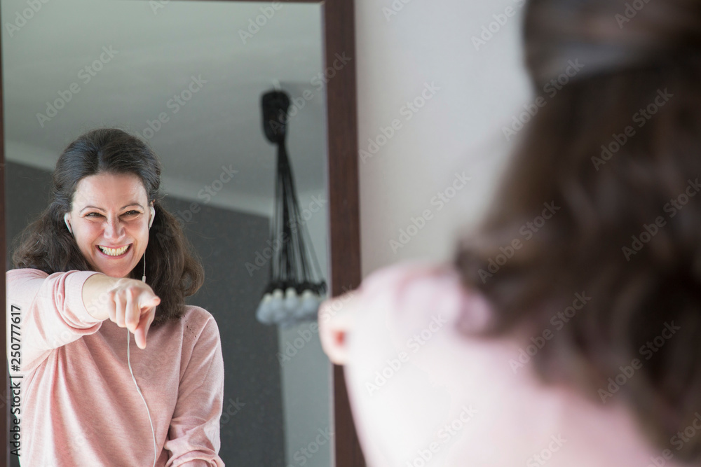Excited young woman dancing in front of mirror - obrazy, fototapety, plakaty 