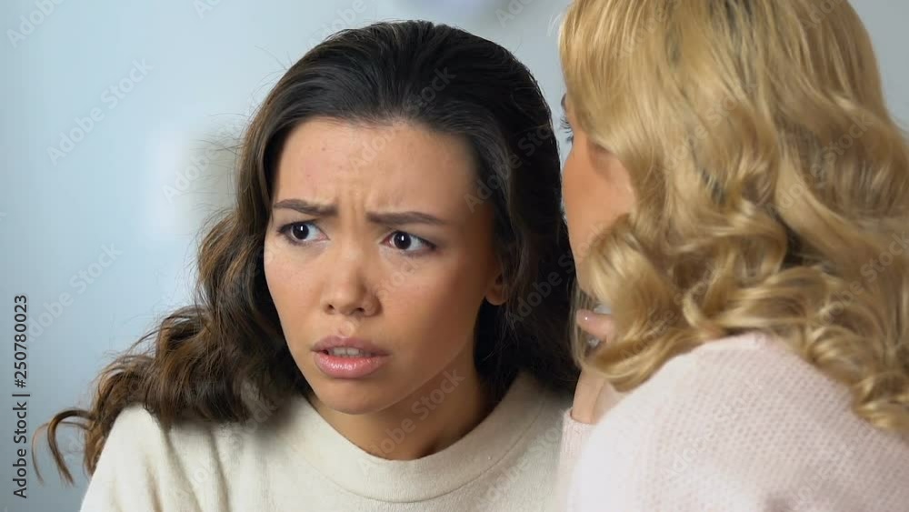 Woman sharing unpleasant news with her asian friend, young ladies gossiping Woman sharing unpleasant news with her asian friend, young ladies gossiping