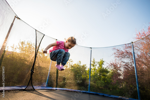 Child jumping high in the air on a trampoline