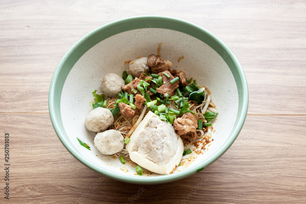 Dry noodle with pork meatball and Tofu with pork on the wood table Dry noodle with pork meatball and Tofu with pork on the wood table