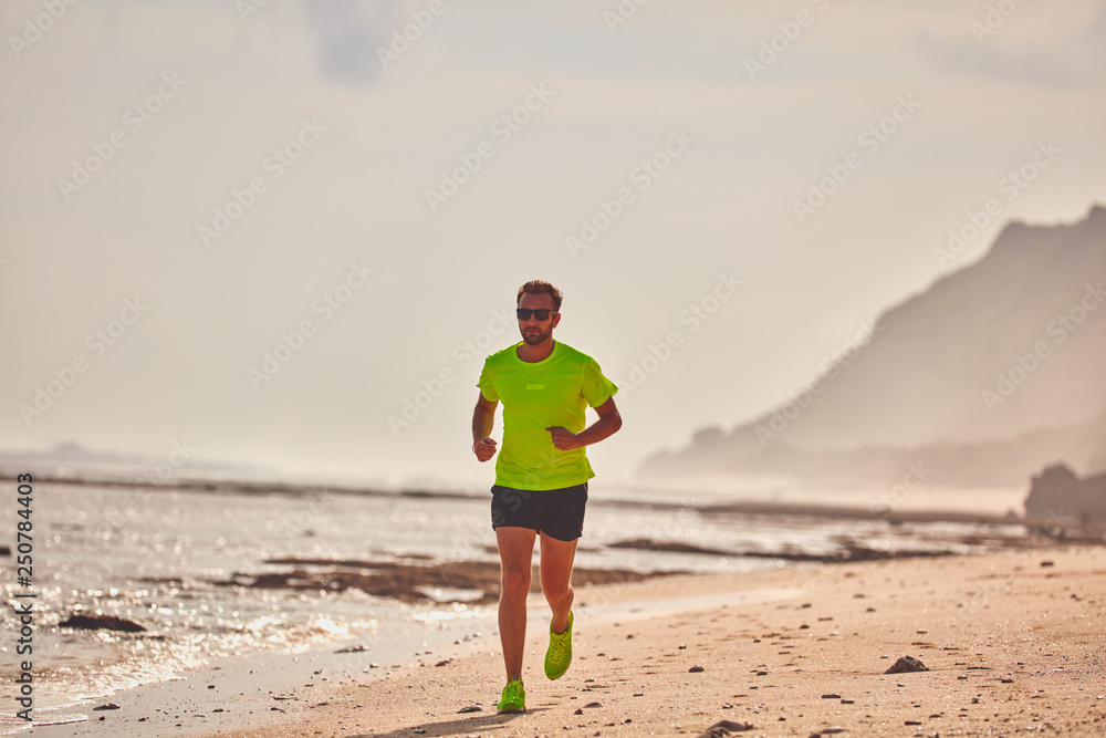 Man running / jogging on a tropical exotic beach.