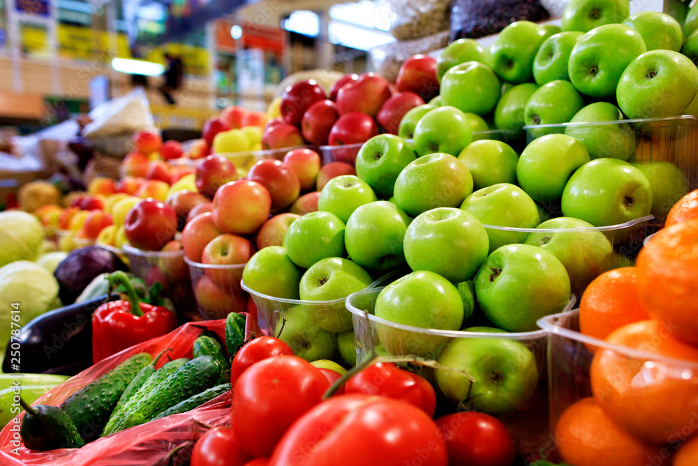 Green, red, yellow apples, fruits and vegetables for sale in the market