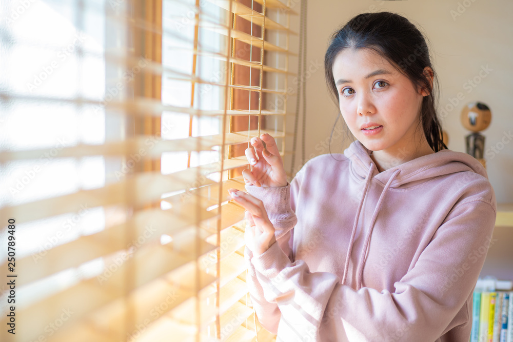 Asian beautiful women looking outdoor by curtain Asian beautiful women looking outdoor by curtain