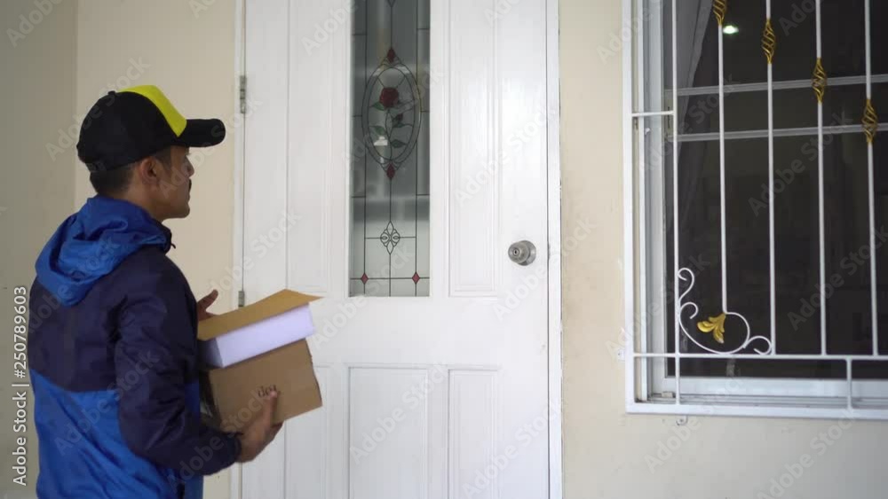 Young courier delivering the parcel boxes to the house. Young courier delivering the parcel boxes to the house.