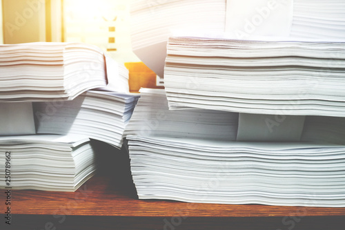 Stack of paper files.Paper documents stacked on wooden desk at workplace.Business Concept. © adisonpk