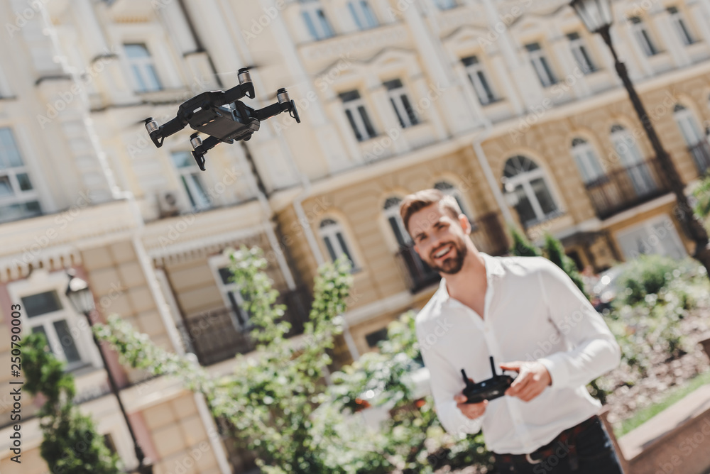 Fototapeta premium Leisure time. Man operating drone. Flying or hovering by remote control outdoors