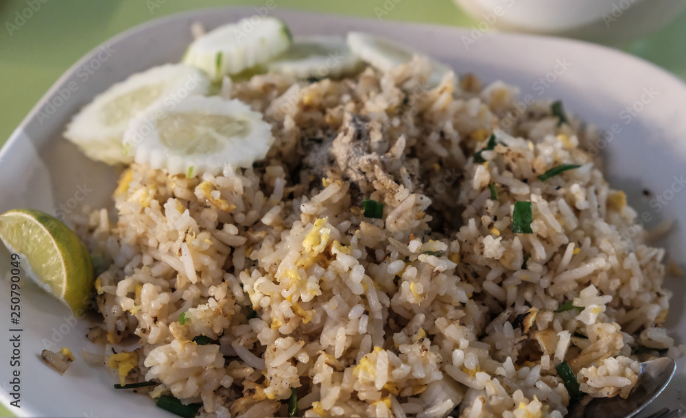 Fried rice with chicken. Prepared and served in a wok. Natural wood in the background. Top view. Fried rice with chicken. Prepared and served in a wok. Natural wood in the background. Top view.