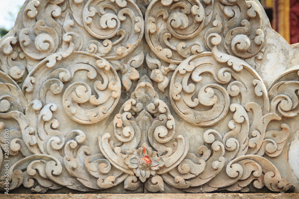 Old white wall design bas-relief with stucco wild flower vine element. Beautiful traditional Thai style stucco wild flower vine patterned for decorative on wall background.