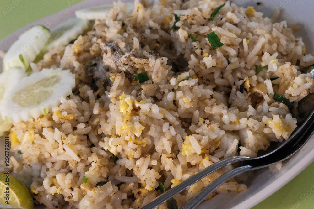 Fried rice with chicken. Prepared and served in a wok. Natural wood in the background. Top view. Fried rice with chicken. Prepared and served in a wok. Natural wood in the background. Top view.