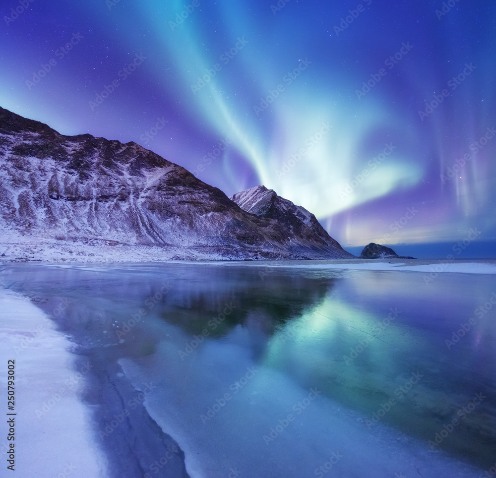Aurora borealis on the Lofoten islands, Norway. Green northern lights above mountains. Night winter landscape with aurora and reflection on the water surface. Norway-image