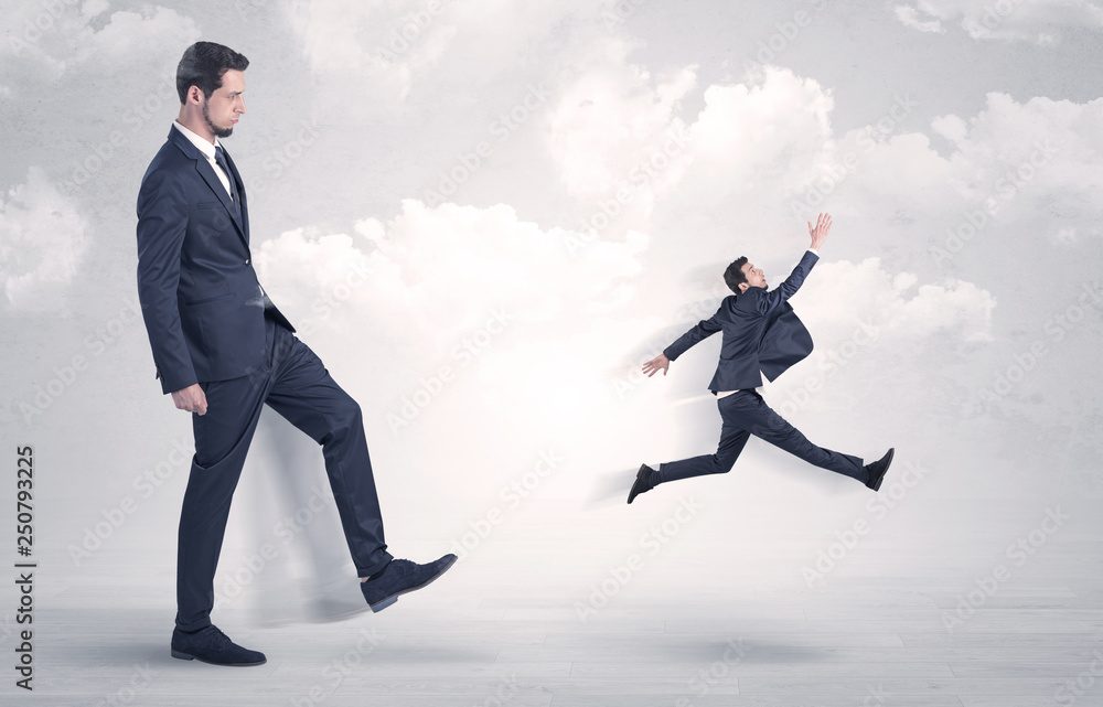 Big businessmen kicking himself as a small employee with cloudy background
Big businessmen kicking himself as a small employee with cloudy background