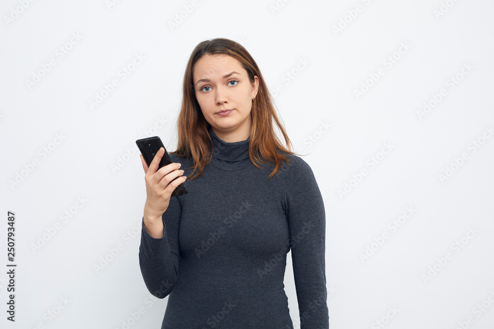 portrait of young woman with mobile phone looking in camera portrait of young woman with mobile phone looking in camera