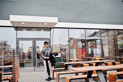 Attractive and handsome stylish indian man wear on shirt and sunglasses standing in the terrace of modern lounge cafe at his work break. © AS Photo Family