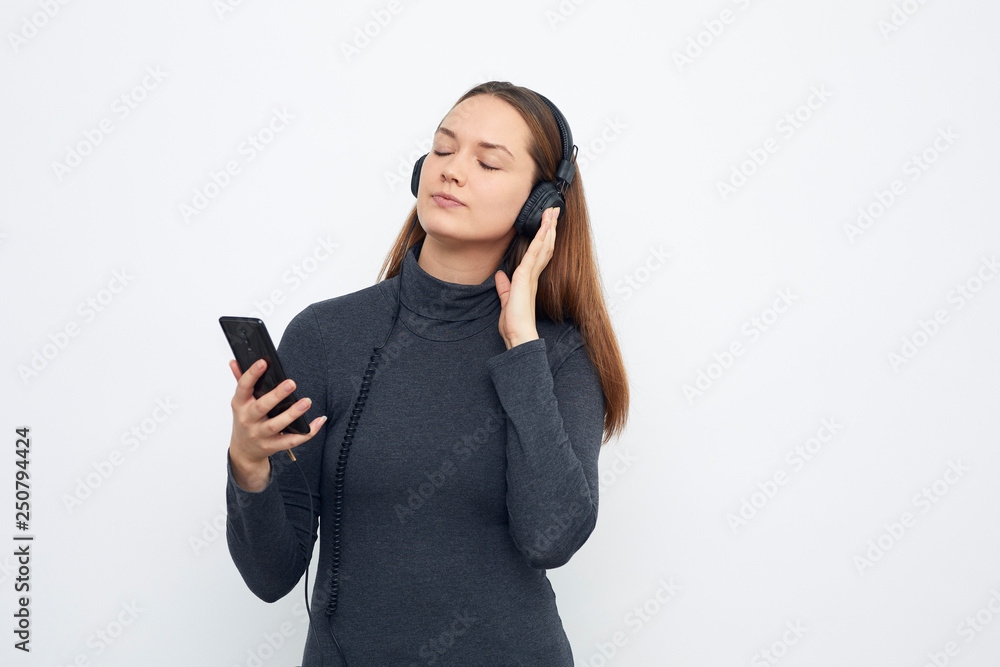 young girl listening to music with headphones enjoying music