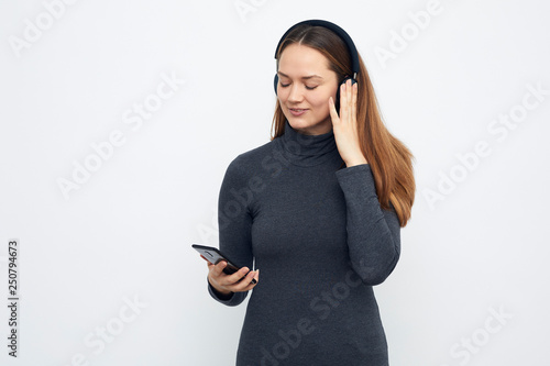 young girl listening to music with headphones enjoying music photo