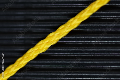 Принти на полотні closeup photo of yellow plastic cord on black background