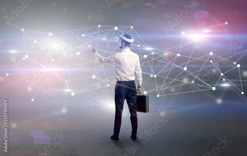 Young businessman standing with vj glasses and checking life-sized connectivity project  