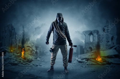 Destroyed place after a catastrophe with man in gas mask and weapon on his hand
