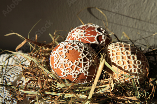 Handmade Easter Eggs decorated with lace tatting in a straw nest. Easter decoration  photo