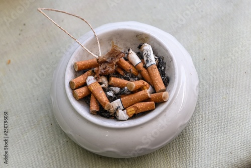 Abstoßend, Häßlich, Ungesund- Aschenbecher mit Zigarettenkippen als Symbol für die abnehmende Attraktivität des Rauchens