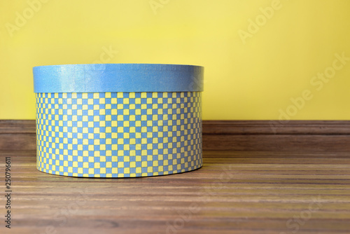 Tableau sur toile decorative hat box blue and yellow on a wooden floor