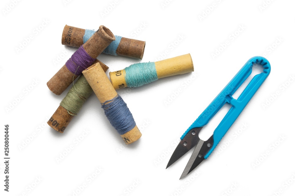 used retro group of thread spools white background with repairing scissors used retro group of thread spools white background with repairing scissors