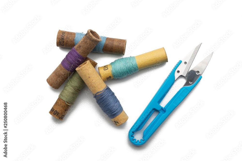 used retro group of thread spools white background with repairing scissors used retro group of thread spools white background with repairing scissors