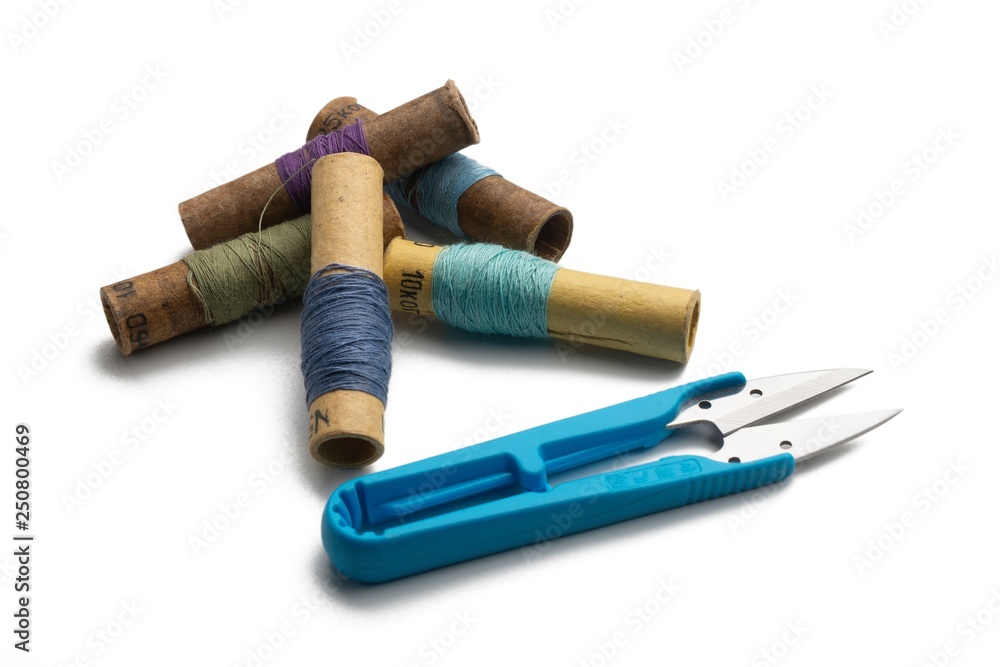 used retro group of thread spools white background with repairing scissors used retro group of thread spools white background with repairing scissors