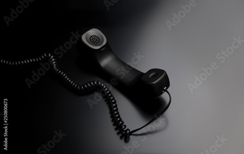 фотографія modern telephone receiver on dark back