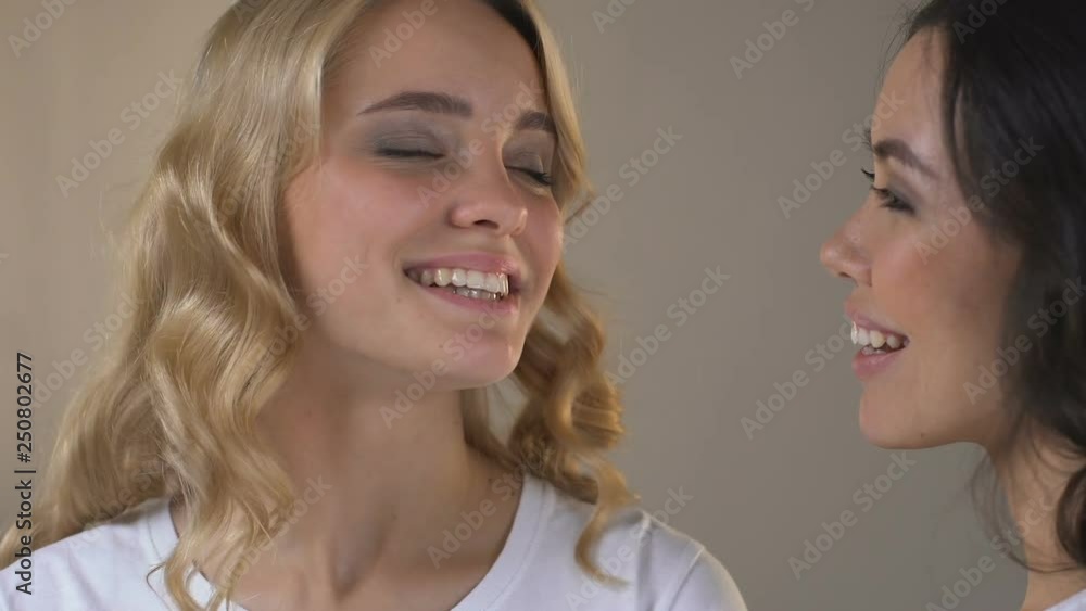 Woman applying powder at cheeks of her beautiful friend, preparation for date Woman applying powder at cheeks of her beautiful friend, preparation for date