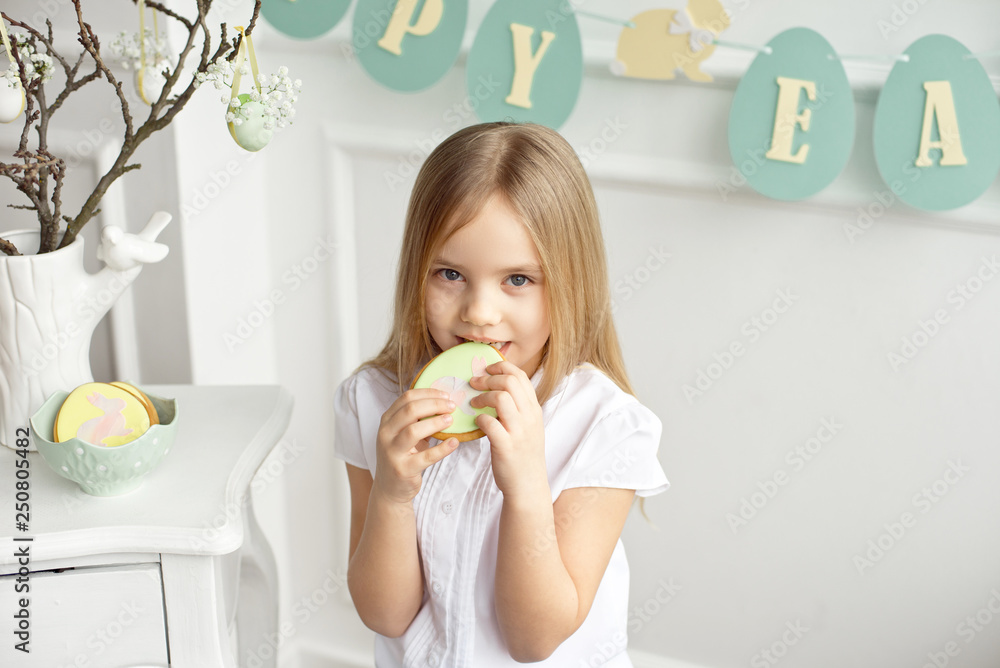 A cute toddler girl in a white shirt is eating with Easter eggs on Easter day. A cute toddler girl in a white shirt is eating with Easter eggs on Easter day.