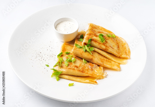 Crepes Suzette with sour cream on the white background