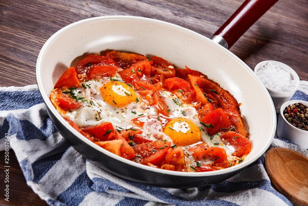 Shakshuka - fried eggs with vegetables in frying pan Shakshuka - fried eggs with vegetables in frying pan