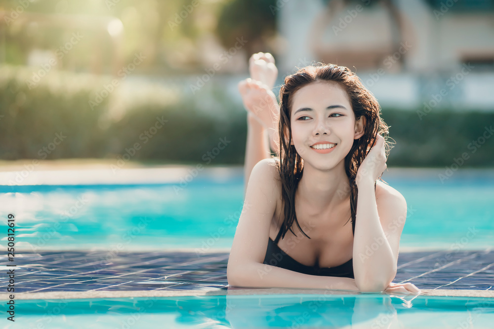 Beautiful Asain women with bikini enjoy summer vacation in the swimming pool.