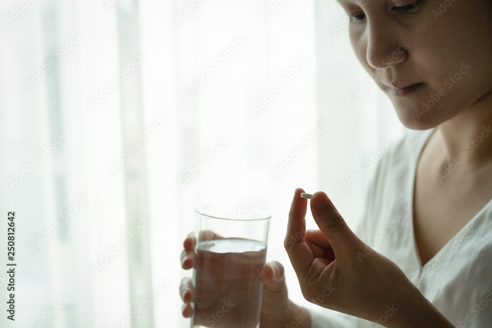headache women hand hold medicine with a glass of water, healthcare and medicine recovery concept headache women hand hold medicine with a glass of water, healthcare and medicine recovery concept
