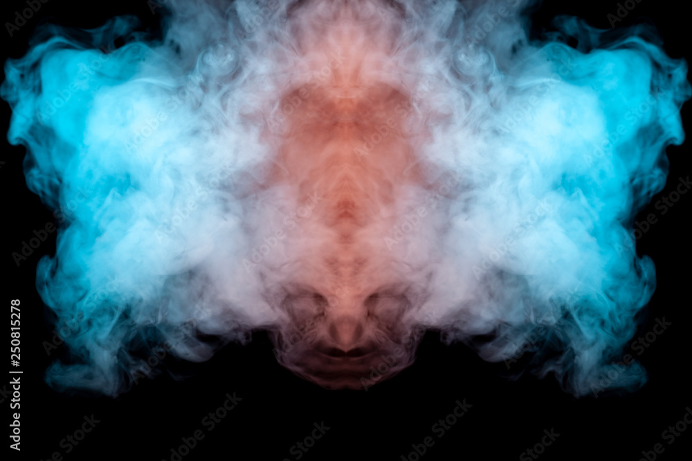 Obraz premium Mystical pattern of green, blue and pink colored smoke in the shape of a ghost's face with big eyes and an open mouth creating a feeling of fear on a black isolated background from a horror movie.