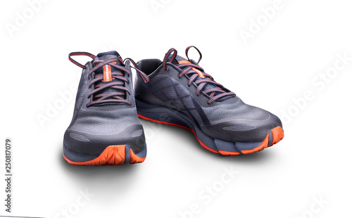 Front view of gray and orange trainers isolated on a white background.