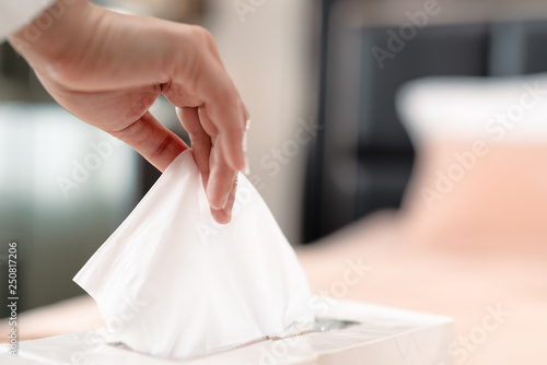 women hand picking napkin/tissue paper from the tissue box photo