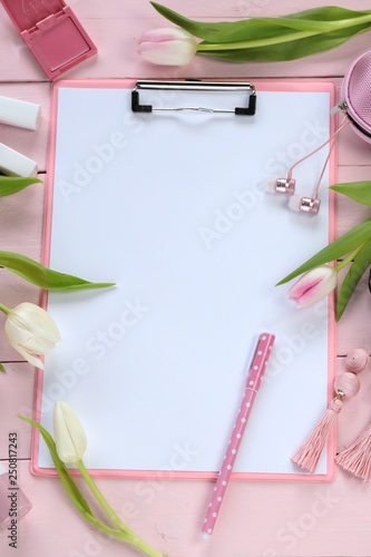 Spring fashion Flat lay.Spring to-do list.International Women's Day.Clipboard pink, fashion accessories, cosmetics and white tulips flowers on a wooden background.top view, copy space
