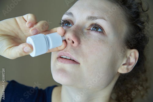Sick girl sprays the spray from runny nose into the nasal pass