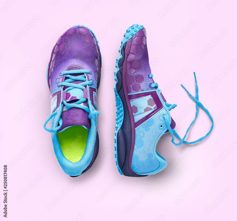 Fototapeta Top view of blue and purple trainers isolated on a pink background.