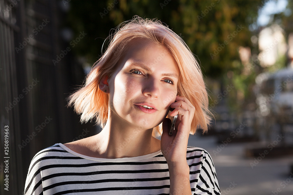 young beautiful girl talking on a cell phone,  telephone conversation,  walk around the city
