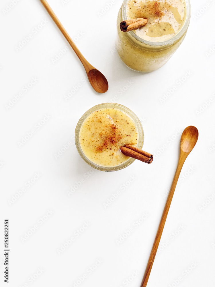 Fototapeta premium Mango yogurt smoothie with chia seeds and cinnamon on a white background, top view copy space