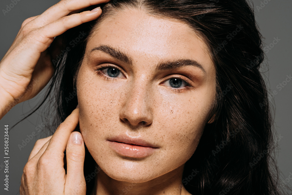 Obraz premium Portrait of attractive girl with freckles on face isolated on grey