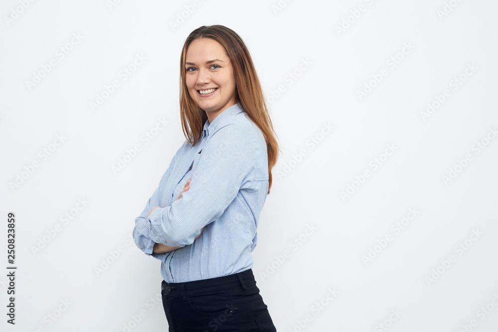 portrait of young happy woman looks in camera crossed arms portrait of young happy woman looks in camera crossed arms