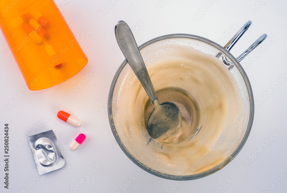 Medication during breakfast, capsules next to a glass of coffee, conceptual image, horizontal composition Medication during breakfast, capsules next to a glass of coffee, conceptual image, horizontal composition