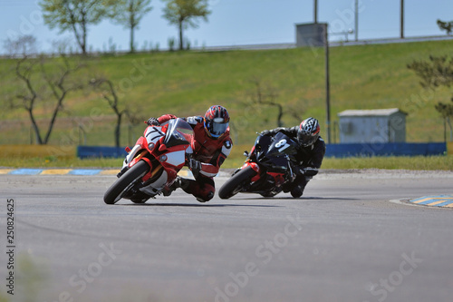 Road racing motorcykel in high speed into a curve, panning shot photo
