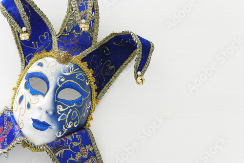 blue with gold elegant traditional venetian mask over white wooden background