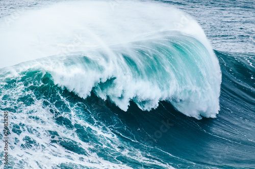 Obraz na plátně surfing big waves at Nazaré, Portugal